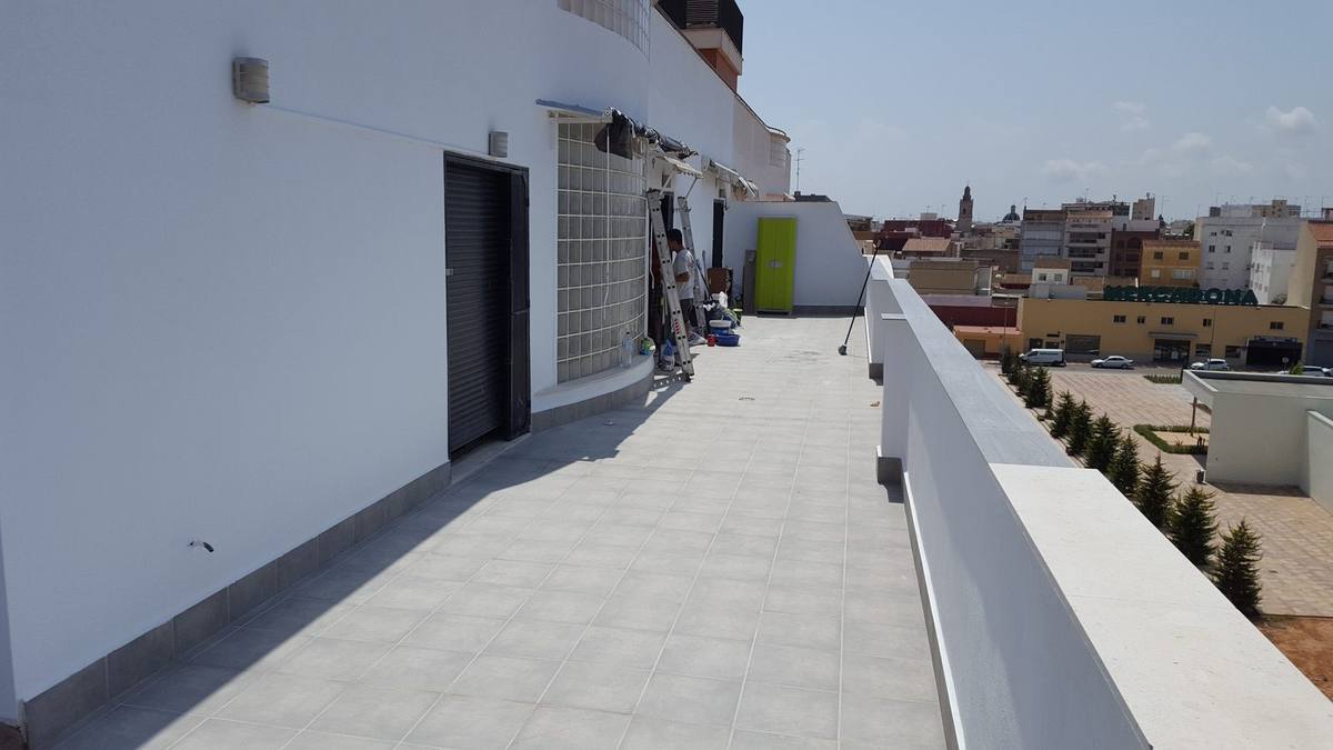 Muro de obra nueva levantado en una azotea de Alzira