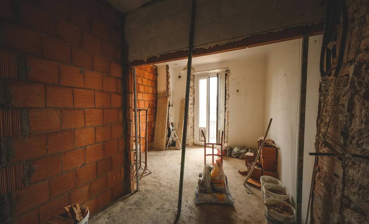 Interior en obra con muro de ladrillo visto
