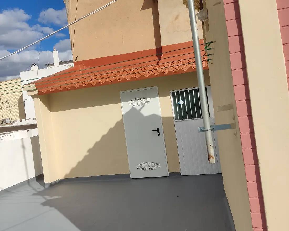 Acceso a la azotea ya impermeabilizado, con las puertas repintadas