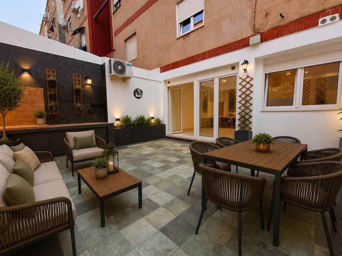 Patio reformado con zona de estar, comedor exterior y jardinera vertical