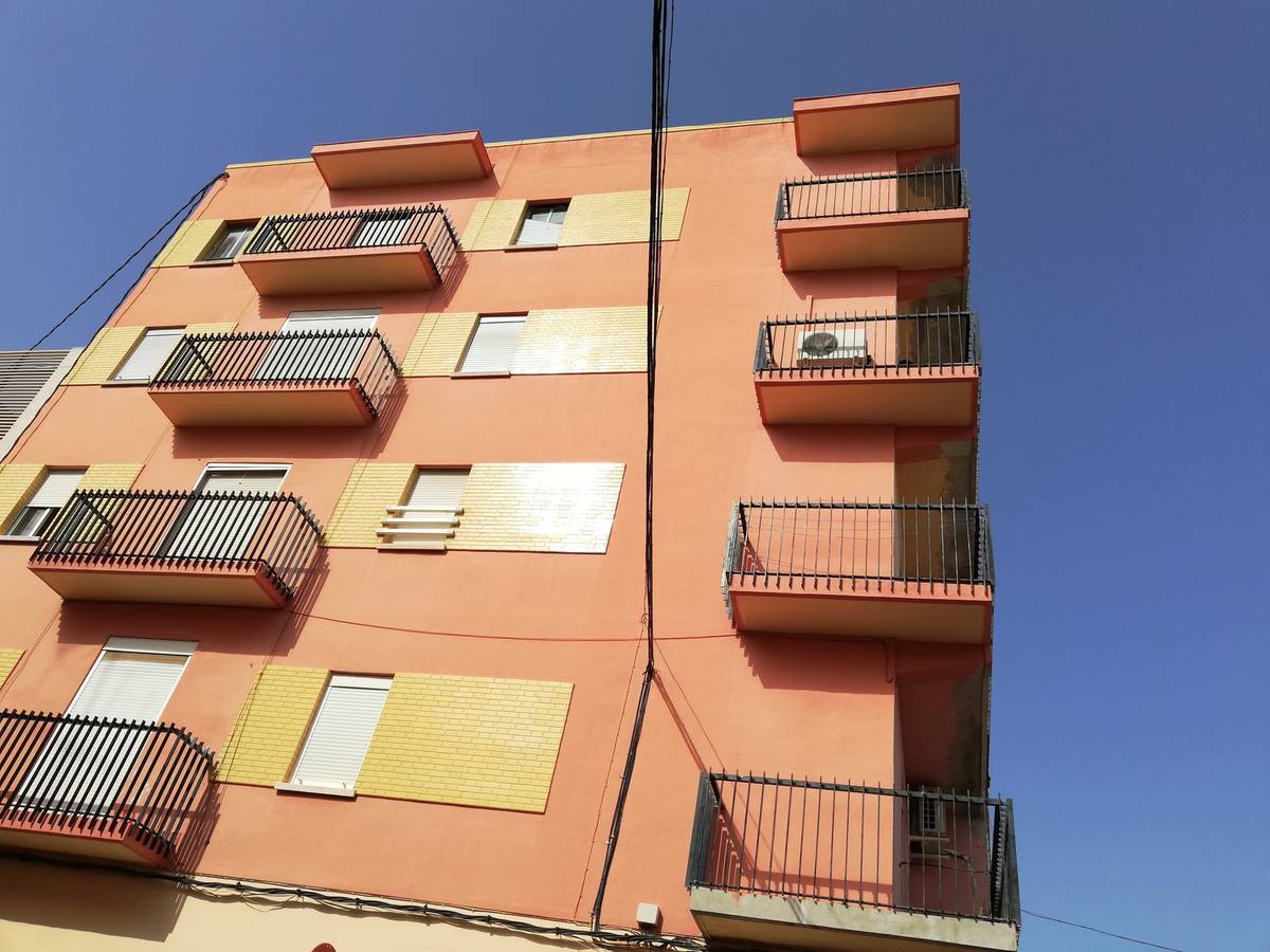 Edificio con la cornisa reparada y la fachada repintada, en Alzira
