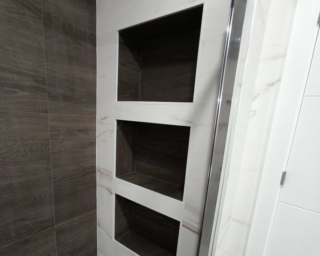 Hornacinas alicatadas en efecto madera dentro de la ducha, en la vivienda de Silla