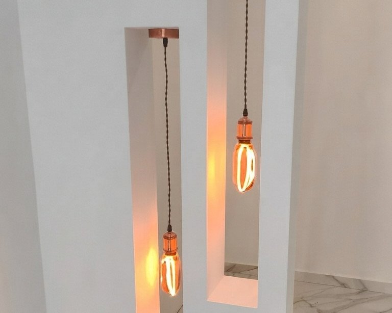 Hornacinas verticales con lámparas colgantes de luz cálida, en la vivienda de Silla