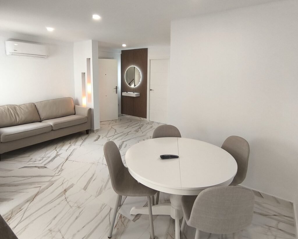 Salón comedor de la vivienda de Silla ya reformada, con suelo tipo mármol y hornacinas iluminadas
